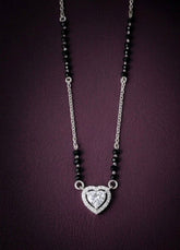 Necklace with heart-shaped diamond pendant on a dark background