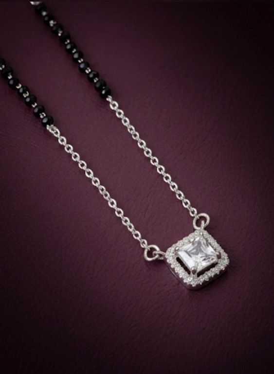 Silver necklace with a diamond pendant on a dark purple background