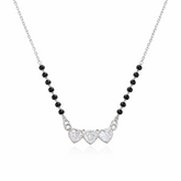 Necklace with heart-shaped charms and black beads on a white background