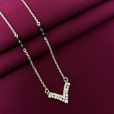 Silver necklace with a V-shaped pendant on a purple fabric background