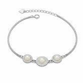 Silver bracelet with three pearls on a white background