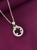 Silver necklace with a circular pendant on a purple fabric background