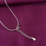Silver chain necklace on a purple fabric background