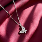 Silver necklace with leaf design on a red fabric background