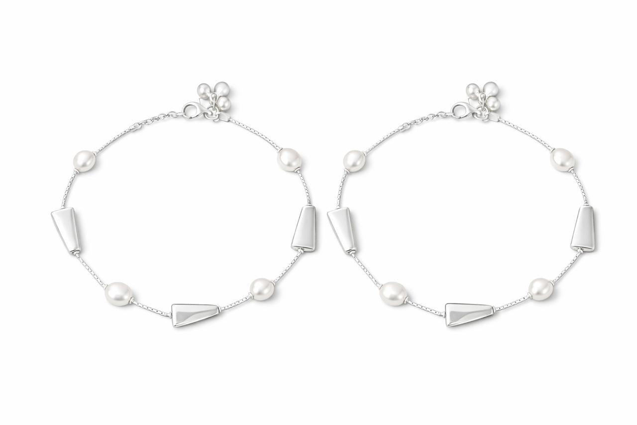 Pair of silver payal with geometric designs on a white background