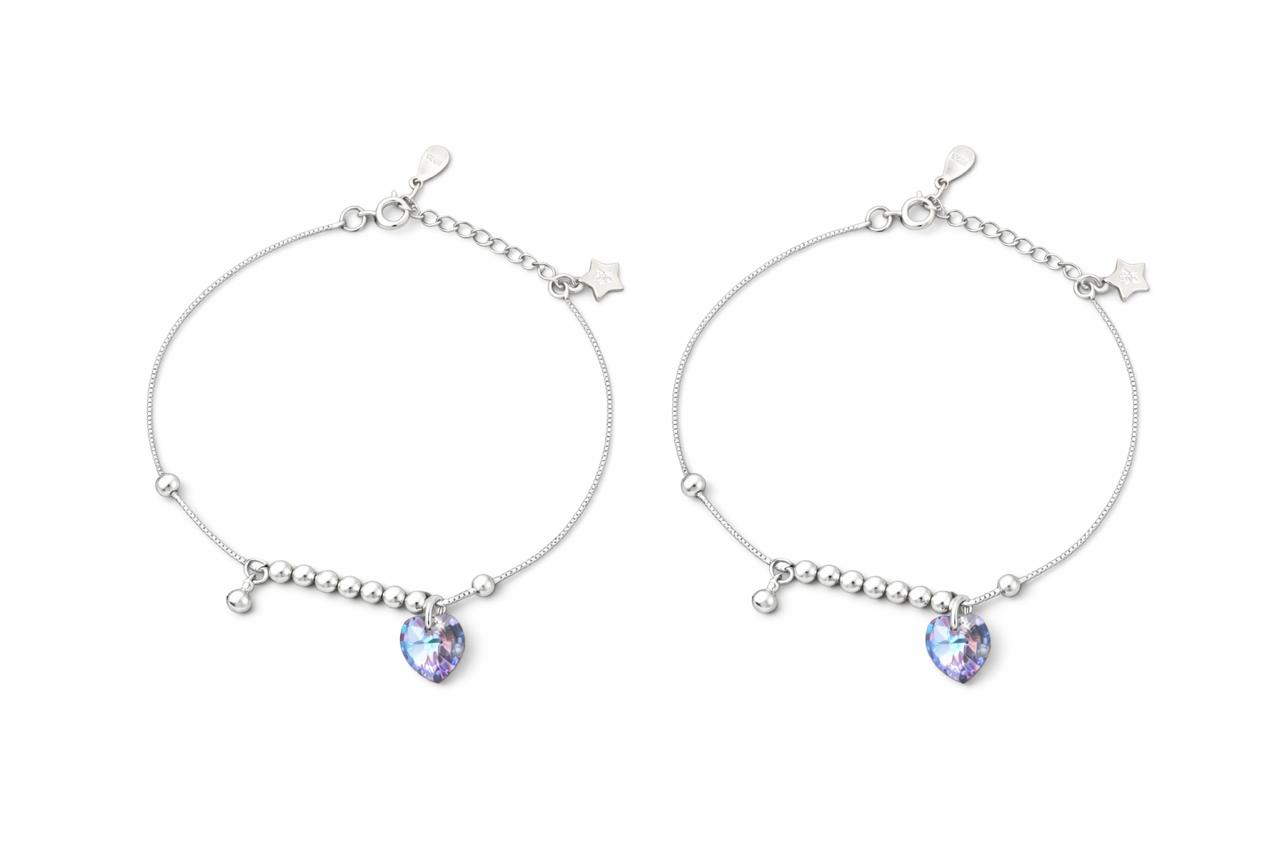 Two silver payal with heart-shaped gemstones on a white background