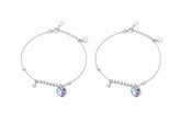 Two silver payal with heart-shaped gemstones on a white background