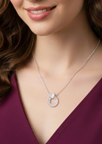 Close-up of a woman wearing a diamond necklace with a purple top.