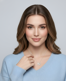 Woman wearing a light blue sweater and a necklace with a pendant against a gray background