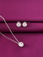Silver jewelry set with earrings and a necklace on a purple fabric background