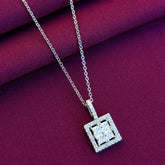 Silver necklace with a square pendant on a purple fabric background