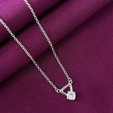 Silver necklace with a diamond pendant on a purple fabric background