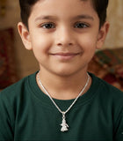Young boy wearing a necklace with a silver pendant indoors