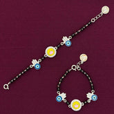 pair of silver bracelets with colorful charms on a purple background
