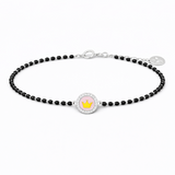Black beaded bracelet with a round charm featuring a pink flower and gold crown on a white background.