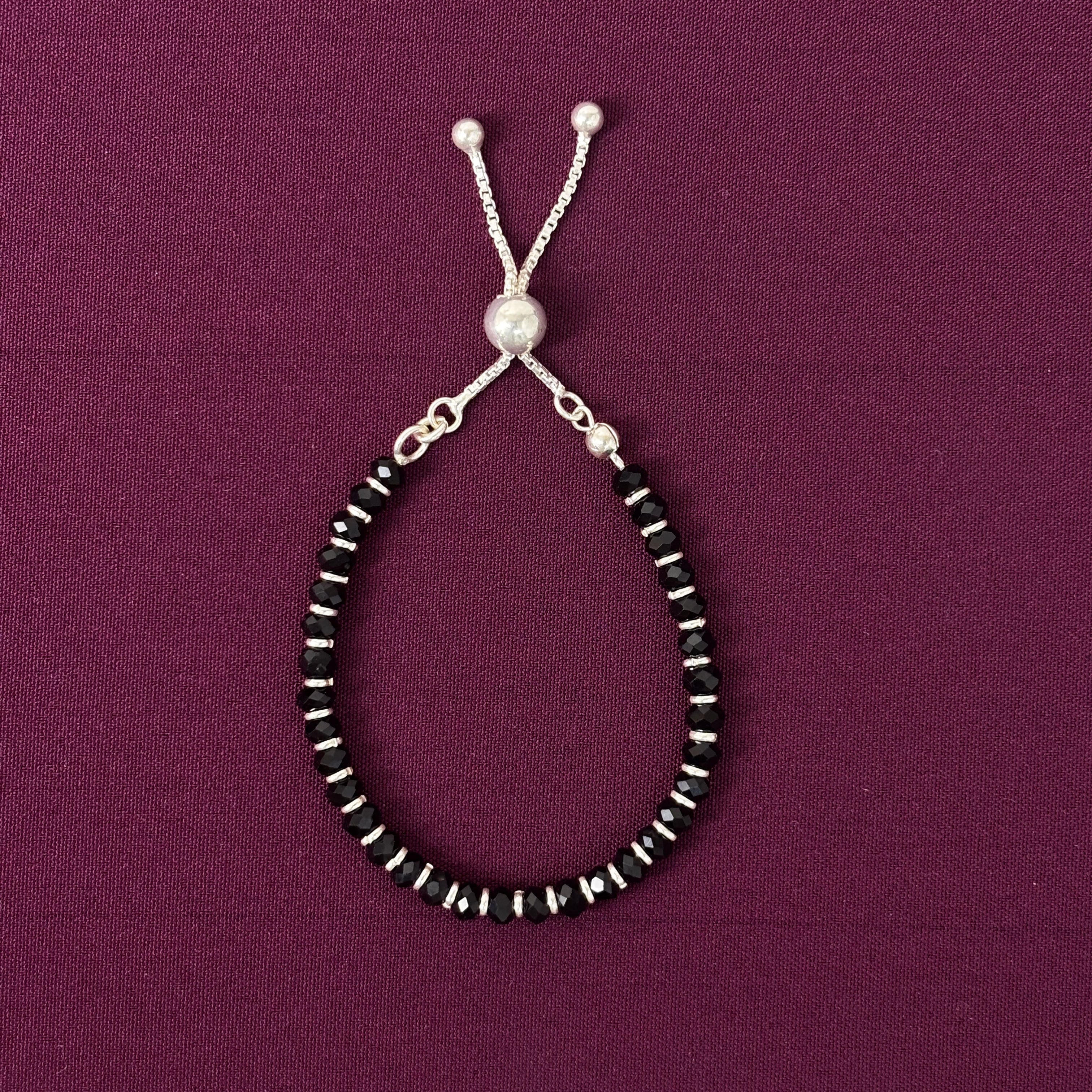 Beaded bracelet with black and silver beads on a purple background