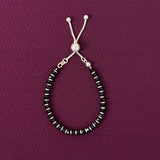 Beaded bracelet with black and silver beads on a purple background