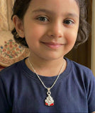 Child wearing a blue shirt with a silver necklace featuring a ganesh pendant