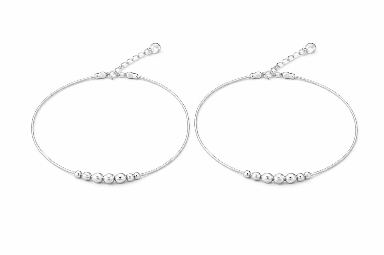 Pair of silver anklet with bead detailing on a white background