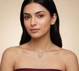 Woman wearing a silver necklace with a pendant against a beige background