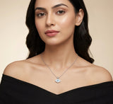 Woman wearing a necklace with an eye pendant on a beige background