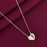 Heart-shaped pendant necklace on a burgundy fabric background