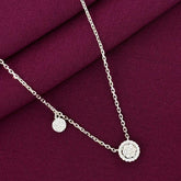 Silver necklace with circular pendants on a purple fabric background