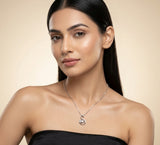 Woman wearing a silver necklace against a beige background