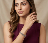 Woman wearing a purple dress and bracelet against a beige background