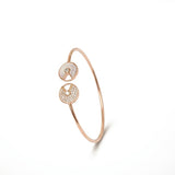 Rose gold bracelet with circular designs on a white background