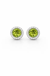 Pair of round green gemstone earrings with silver borders on a white background