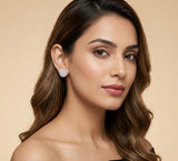 Woman wearing diamond earrings against a beige background