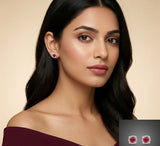 Woman wearing red gemstone earrings with a beige background