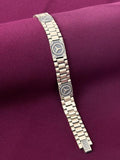 Silver bracelet with Mercedes-Benz logo on a purple fabric background