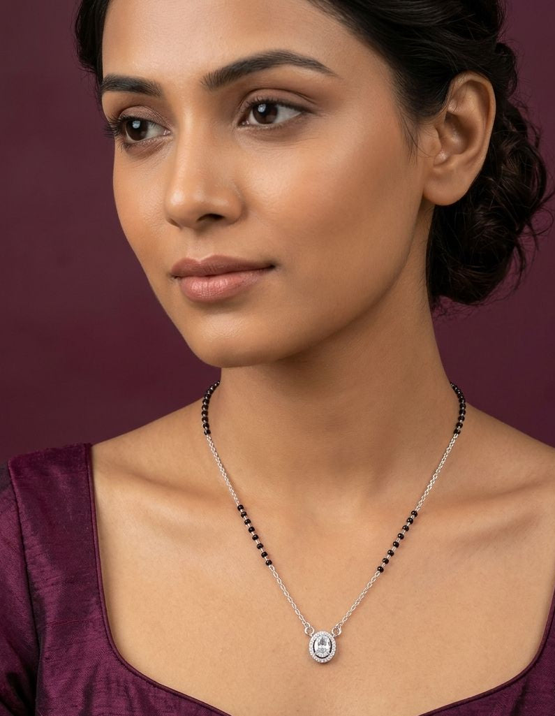 Woman wearing a necklace against a dark background