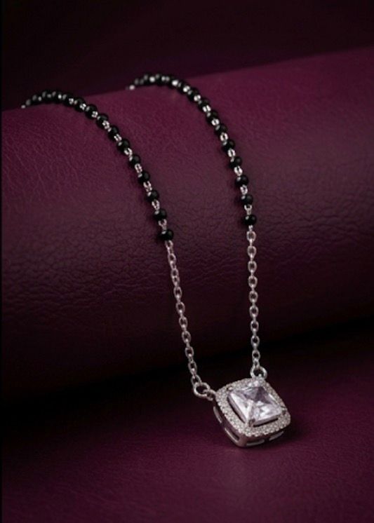 Necklace with a square pendant on a purple surface