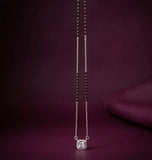 Silver necklace with a pendant on a dark purple background