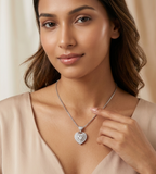 Woman wearing a heart-shaped diamond necklace against a neutral background