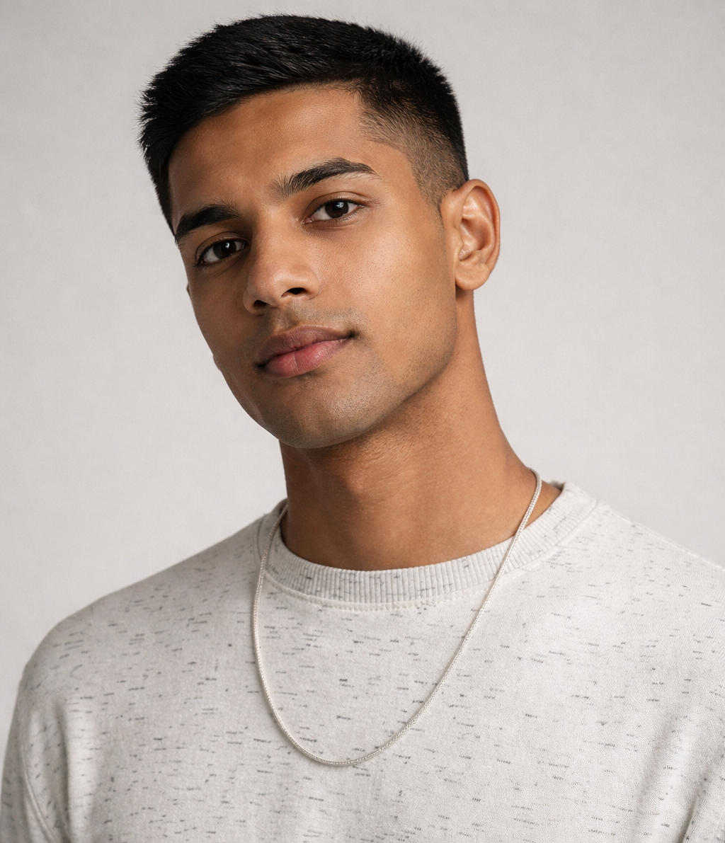 Man wearing a light gray sweater against a plain background