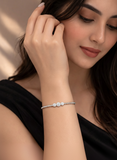 Woman wearing a bracelet with small stones, close-up on arm and hand.