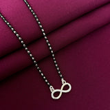 Silver infinity necklace on a purple fabric background