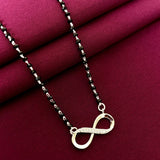 Necklace with an infinity symbol pendant on a red fabric background