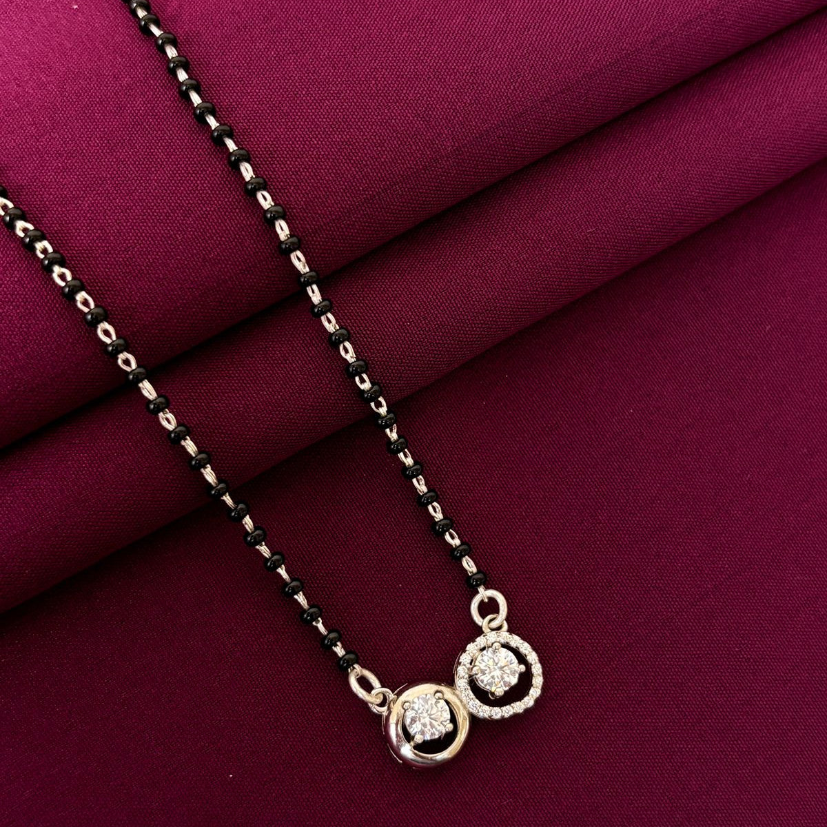 Necklace with a pendant on a maroon fabric background