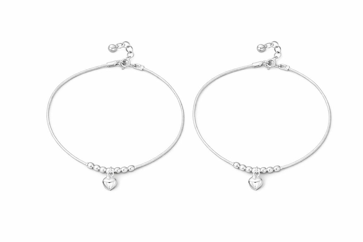Pair of silver payal with heart charms on a white background