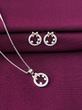 Silver necklace and earrings set on a purple fabric background