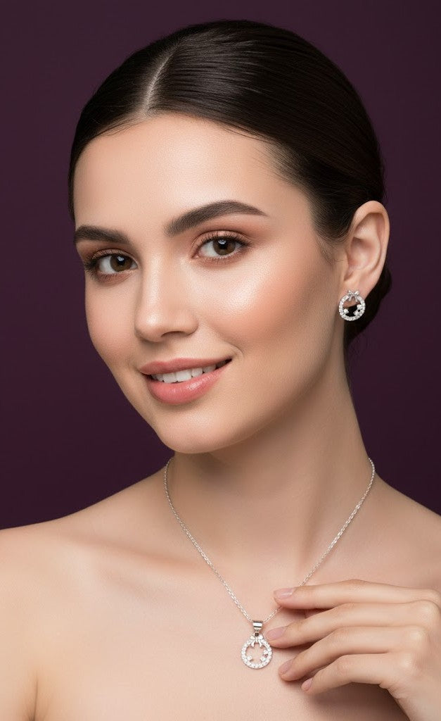 Woman wearing a silver necklace and earrings against a purple background