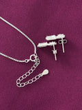 Silver earrings with chain on a purple fabric background