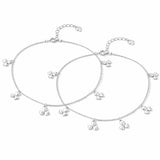 Set of silver anklet with small charms on a white background