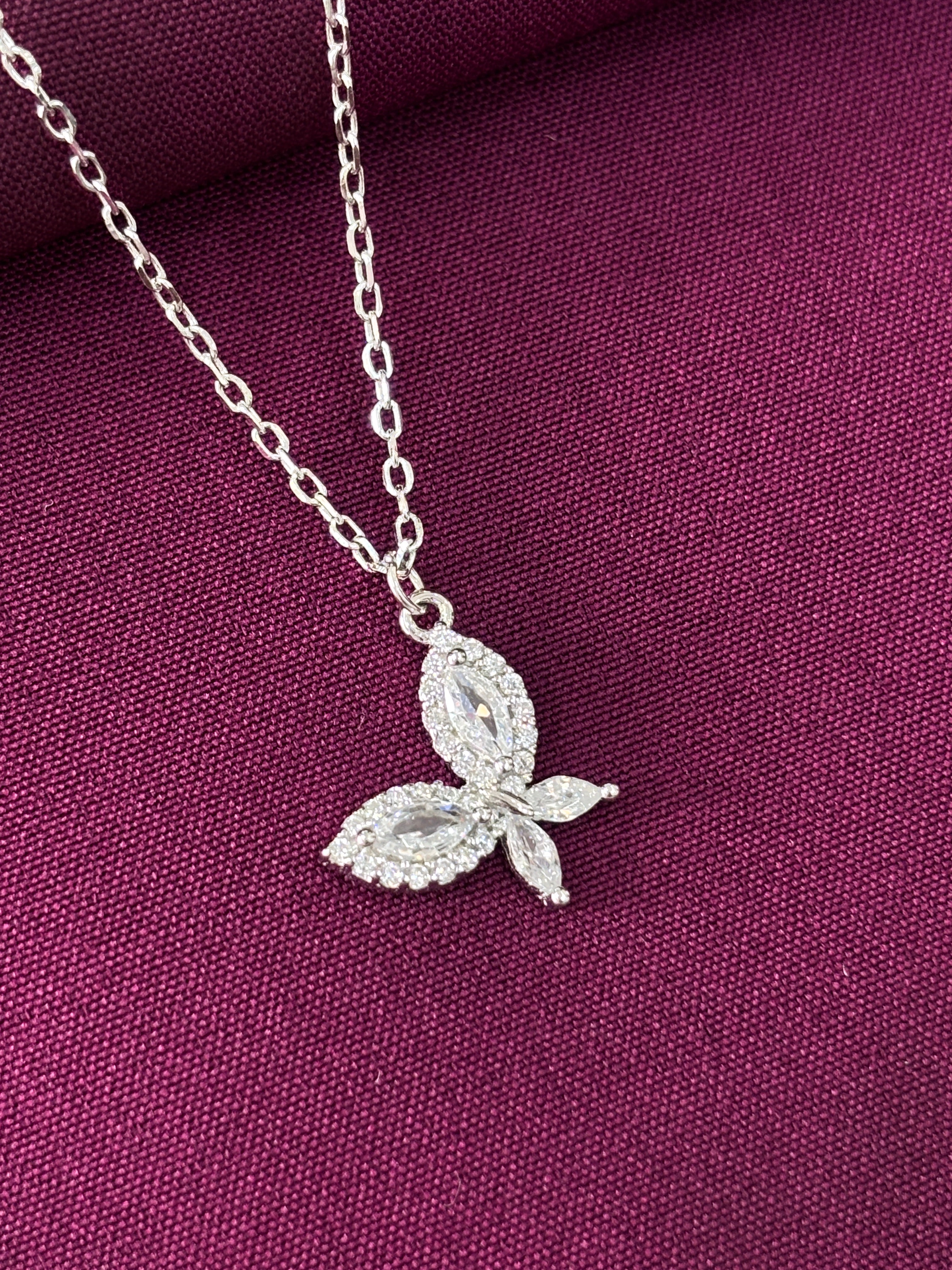 Silver leaf-shaped necklace on a purple fabric background