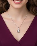 Woman wearing a silver necklace with a crown pendant